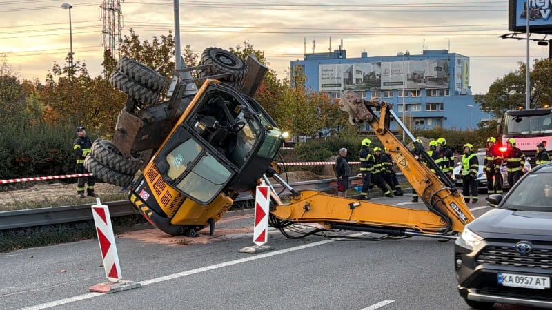 Převrácený bagr zastavil dopravu u nákupního centra v Praze na Chodově. Zasahují hasiči